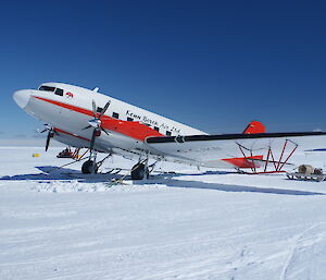 red and white plane on ice runway