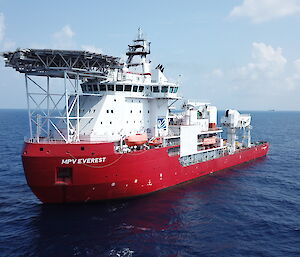 large red and white ship with helipad on the front