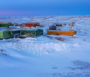research station surrounded by snow-covered hills