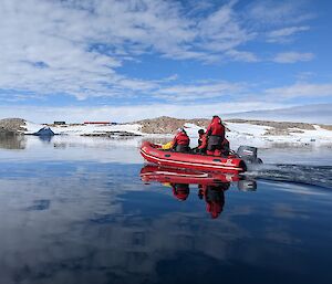 Inflatable boat with expeditioners. Still water conditions. Station in the background.
