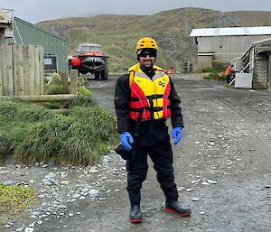 Jamie standing in front of the lark in a dry suit and life jacket