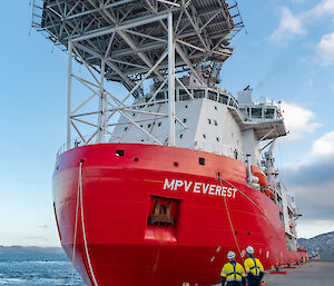 two men dwarfed by giant ship