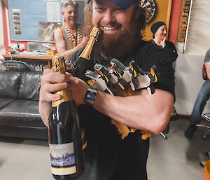 Troy trying to carry 4 awards and sparkling wine bottles