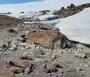 Rocky ground with patches of remaining ice and water