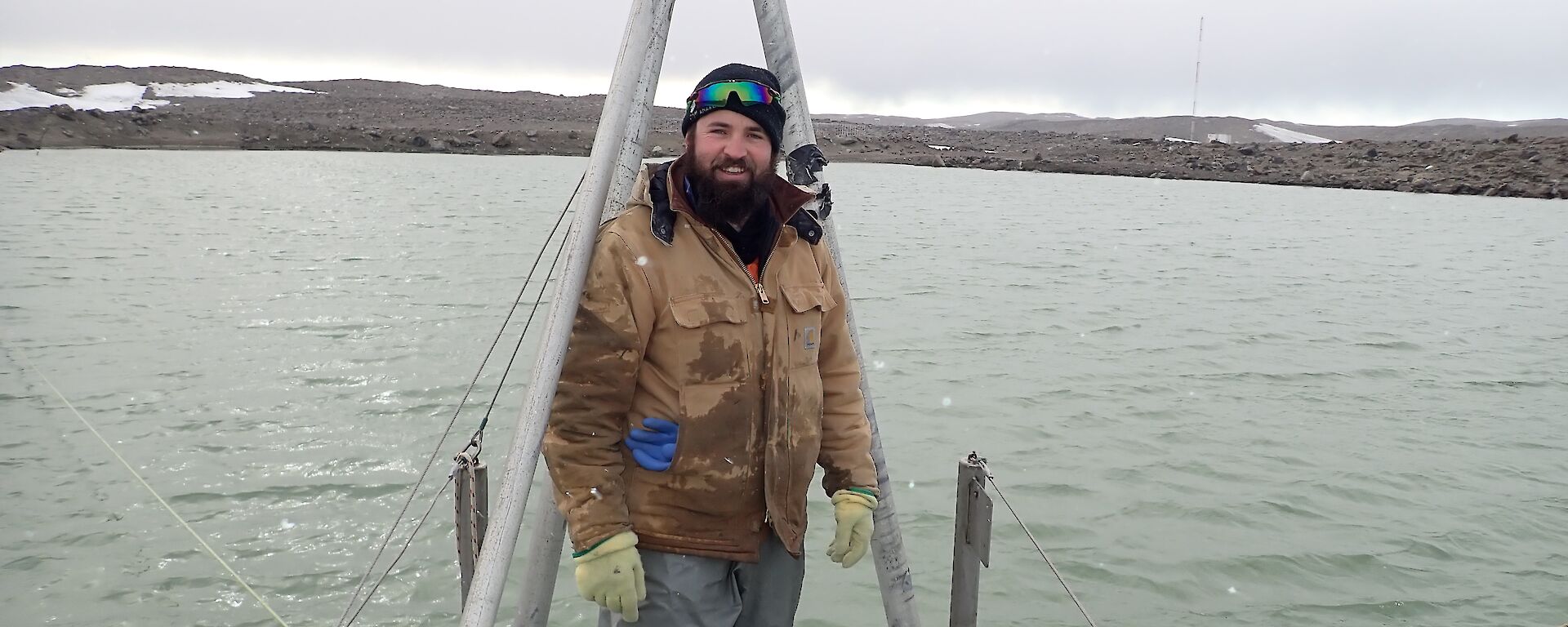 An expeditioner standing at the end of the pontoon looking at the camera