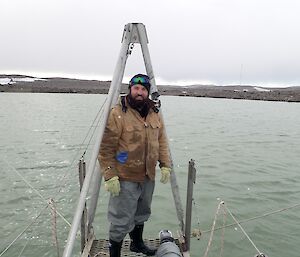 An expeditioner standing at the end of the pontoon looking at the camera