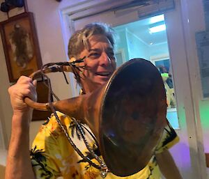 A man holds up a large listening horn to his ear