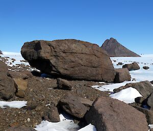 Some large rocks and mountain peaks visible in the snow
