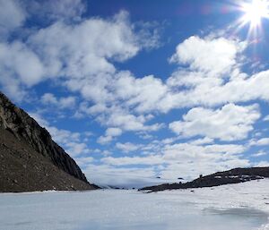 A snowy landscape with patterns of clouds in a blue sky