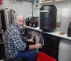 An expeditioner filling up a bottle from the brewing equipment