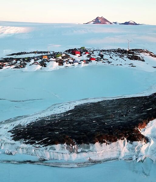 Antarctic research station from the air with mountain in background