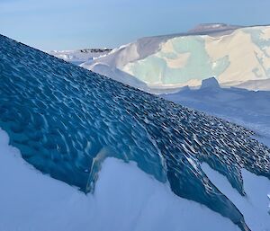 Dimpled jade ice in close up peeping our from an iceberg