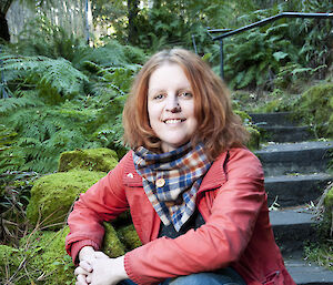Portrait of a woman sitting on moss covered stone steps