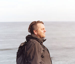 Side portrait of a man standing by the ocean