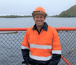 man in fluro on a boat with island in the background