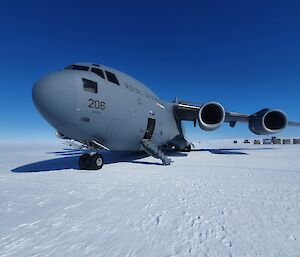 A C17 plane sits on the ice with cargo containers unloaded at the rear