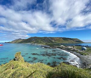 Looking down from a hill across an isthmus with turquoise sea on one side.  L'Astrolabe sits in the bay,