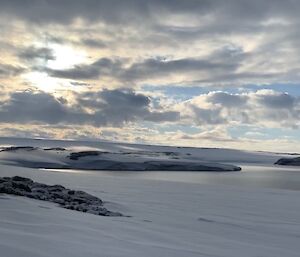 A spectacular landscape of snow and water with a cloudy blue sky