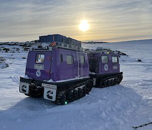 A purple Hagglund vehicle sitting in the snow