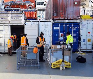 People working, with shipping containers in the background