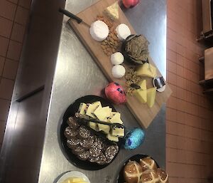 Table with Hot Cross Buns, chocolates and assorted cheeses