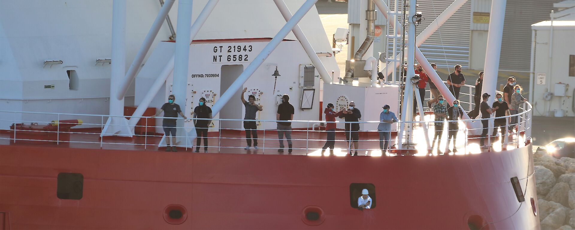 expeditioners on ship bow as approaches dock