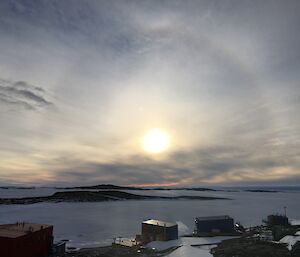 Bright sun with surrounded by a reflecting ring.