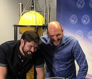 Two scientists looking at the battery components of an ocean mooring.