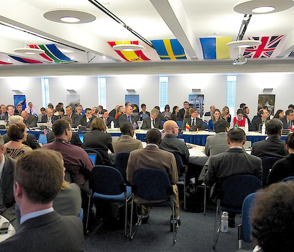 Crowded meeting room with flags