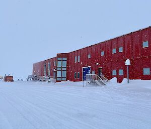 A large red shed building in the snow