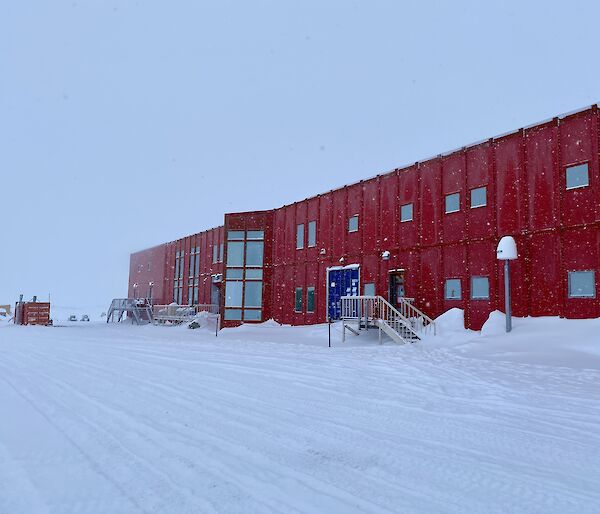A large red shed building in the snow