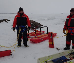 2 men in Mustang suits stand with their sea ice access safety equipment