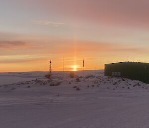 A view across station to an orange sky on the horizon.  A sun pillar can be seen at the centre of shot.