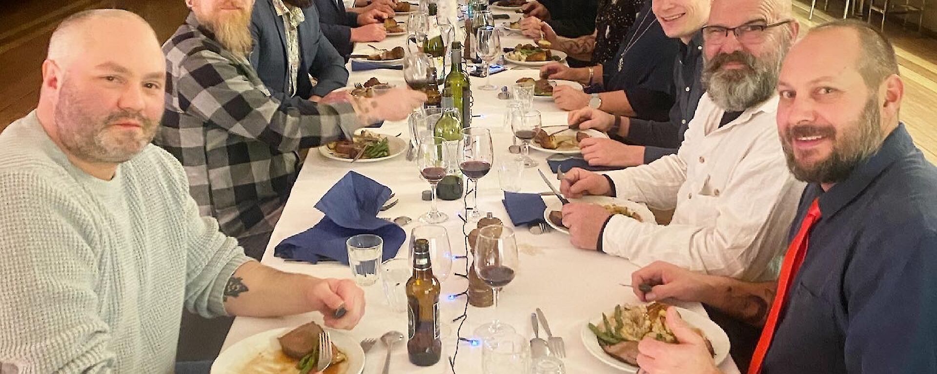 A group of people around a long dining table.