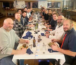 A group of people around a long dining table.