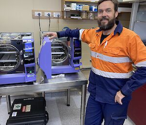 Expeditioner plumber in the medical facility leaning on Autoclave machine