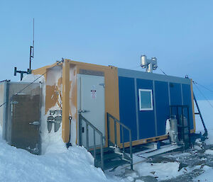 A blue and yellow hut in the snow with a new hut entry sign saying Browning2021.