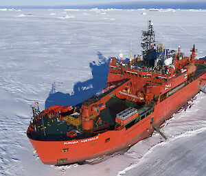 Red icebreaker ship in sea ice.