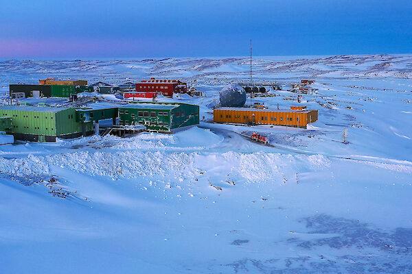 Colourful buildings in a snowy landscape.