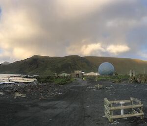 Looking towards an isthmus with buildings and people on the shore, mountains in the background