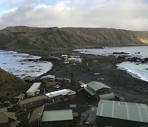 Looking down on to the roofs of a small number of buildings.  The isthmus can be seen with sea on either side, and mountians in the background