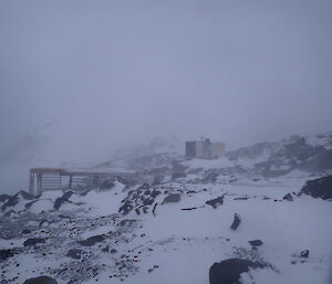 A blizzard scene with a small hut visible through the blowy snow