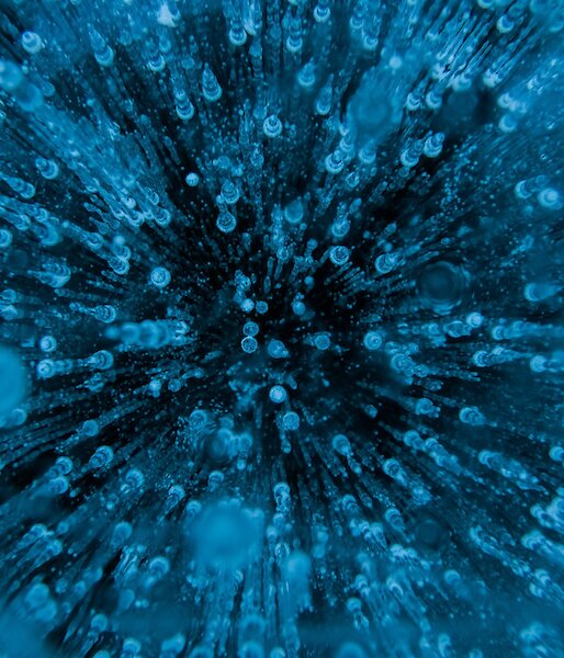 A close up of frozen water showing hundreds of air bubbles trapped in the ice