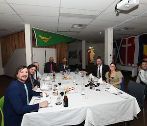 A table of diners smiling to camera.