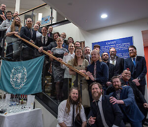 A large group of people standing on some stairs and smiling to camera