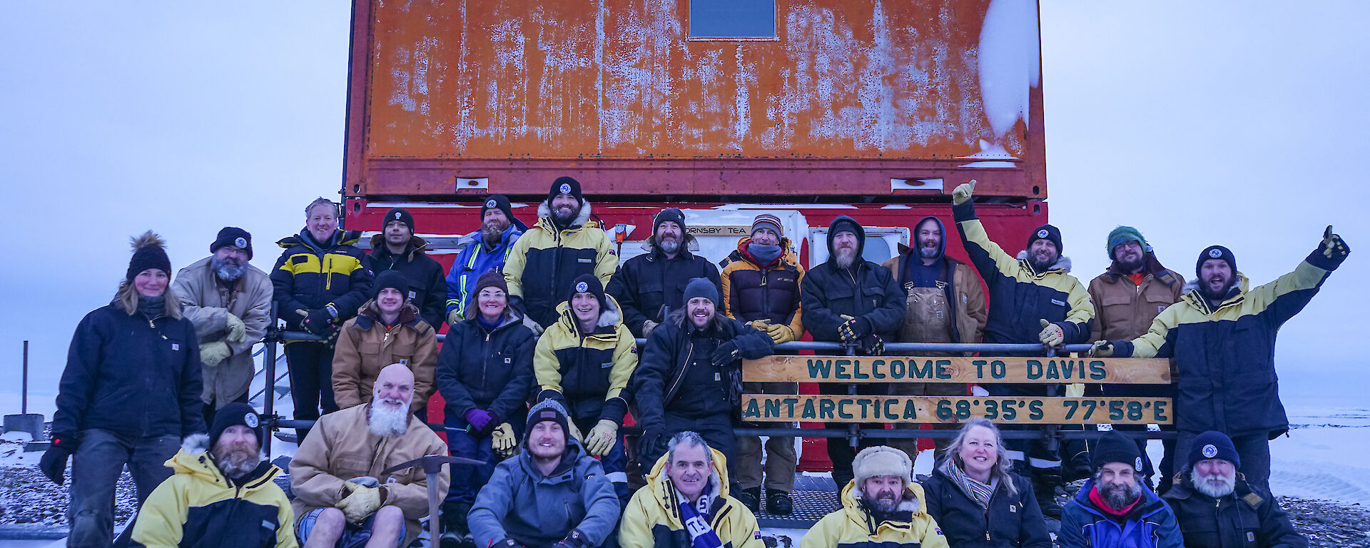 A group of people posing for a picture around the Davis Station sign