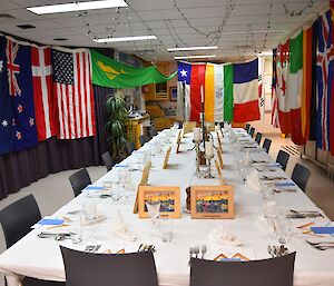 The decorated dinner table which is curtained with flags from around the world.