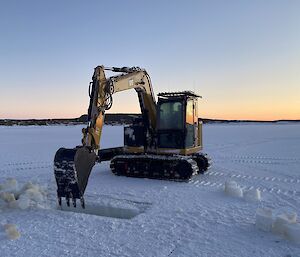 An excavator digging out the sea ice that had been cut with the chainsaw.