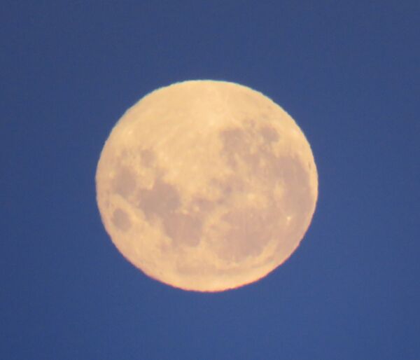 A large full moon in a dark blue sky