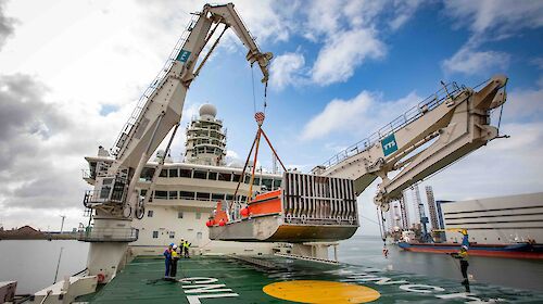 One of Nuyina’s cranes lifting a barge on to the fordeck